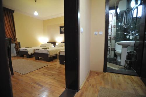 a room with two beds and a bathroom with a mirror at Garni Hotel City in Kruševac