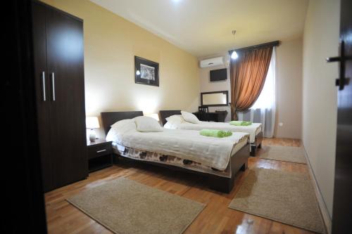 a bedroom with two beds and a window at Garni Hotel City in Kruševac