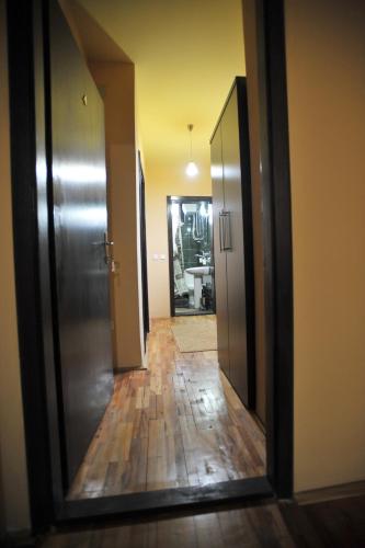 a mirror reflection of a hallway with a door and wooden floors at Garni Hotel City in Kruševac
