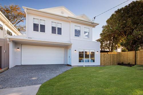 a white house with a garage and a fence at 11 Ann Street in Coolum Beach