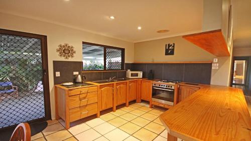 a kitchen with wooden cabinets and a wooden table in it at 15 Clematis Court in Marcoola