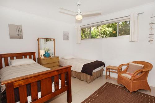 een slaapkamer met 2 bedden, een stoel en een raam bij 35 Santa Monica Avenue in Coolum Beach