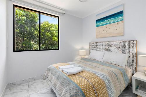 een slaapkamer met een bed en een raam bij Unit 8 Bronte of Coolum in Coolum Beach