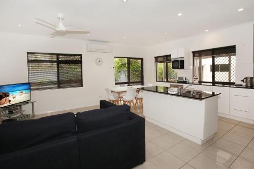 a living room with a couch and a kitchen at 6 Petrie Avenue in Marcoola