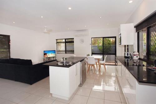 a kitchen and living room with black and white at 6 Petrie Avenue in Marcoola