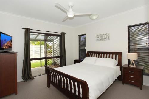 a bedroom with a bed and a ceiling fan at 6 Petrie Avenue in Marcoola