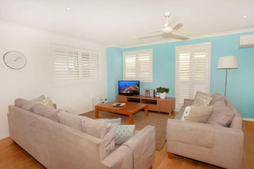 a living room with two couches and a tv at Unit 4 Marcoola Sands in Marcoola