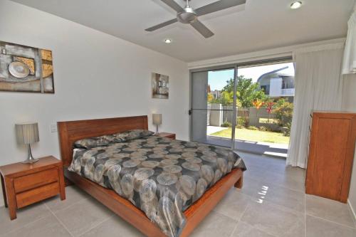 a bedroom with a bed and a large window at 48 Boardrider Crescent in Marcoola