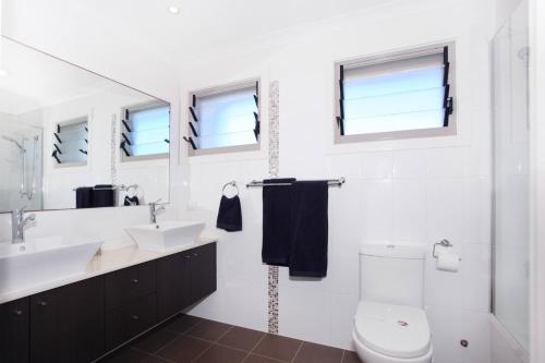 a white bathroom with a sink and a toilet at 15 Wave Crescent in Marcoola