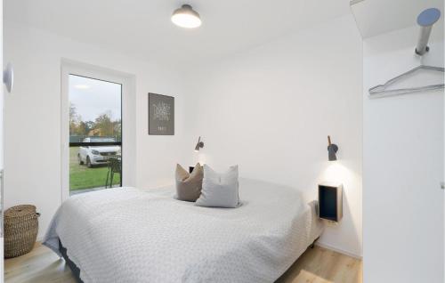 una camera bianca con un letto e una finestra di Stunning Apartment In Lembruch-dmmer See With Kitchenette a Lembruch