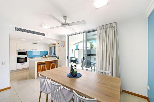 a kitchen and dining room with a wooden table and chairs at Unit 30-31 12 Perry Street in Coolum Beach