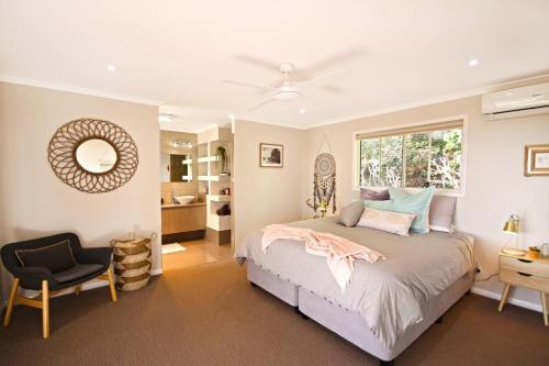 1 dormitorio con 1 cama, 1 silla y 1 ventana en Stunning Home With Spectacular Views en Coolum Beach