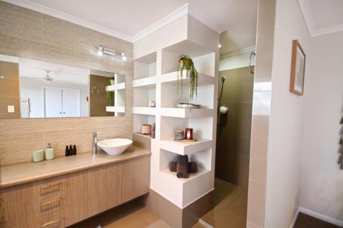 a bathroom with a sink and a mirror at Stunning Home With Spectacular Views in Coolum Beach