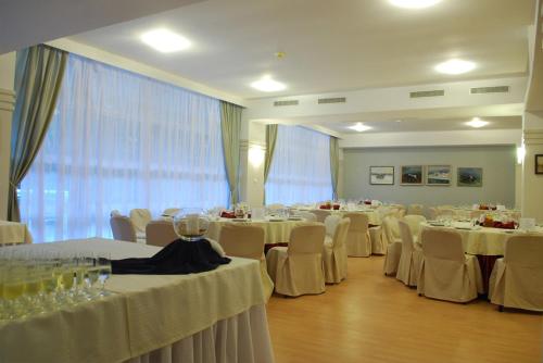 a room filled with tables and chairs with white table cloth at Hotel Akor in Bydgoszcz