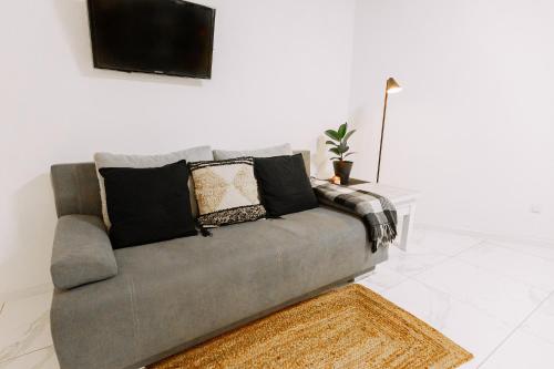 a grey couch with pillows on it in a living room at Black&White Нова стильна квартира на Київській in Ternopilʼ
