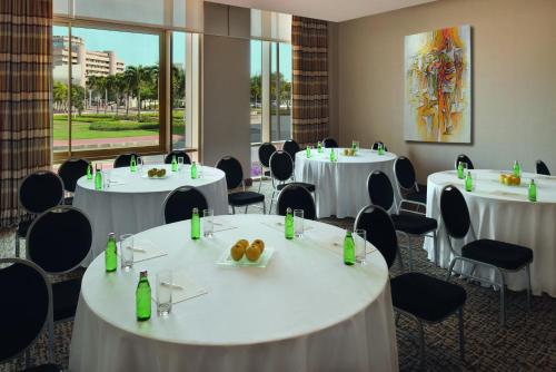 a conference room with white tables and chairs at Mövenpick Ambassador Hotel Accra in Accra