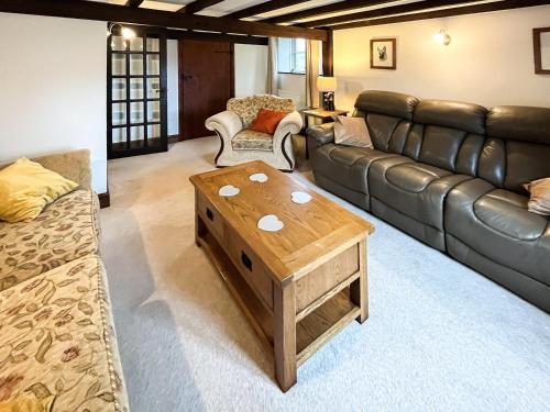 uma sala de estar com um sofá e uma mesa de centro em Cowslip - 23653 em Bradworthy