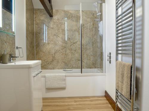 uma casa de banho com um chuveiro e um lavatório. em Cowslip - 23653 em Bradworthy