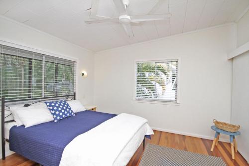 a bedroom with a bed and a ceiling fan at 25 Goongilla Street in Yaroomba