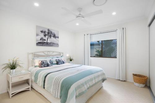 a white bedroom with a bed and a window at 22 Sorrento Avenue in Coolum Beach