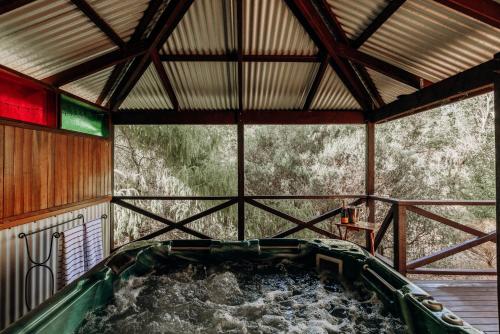 - une grande baignoire dans un bâtiment avec de l'eau dans l'établissement Balingup Jalbrook Cottages Jalbrook Estate, à Balingup