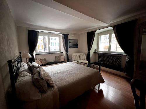 een slaapkamer met een groot bed en 2 ramen bij San Lorenzo Central Apartment in Genua
