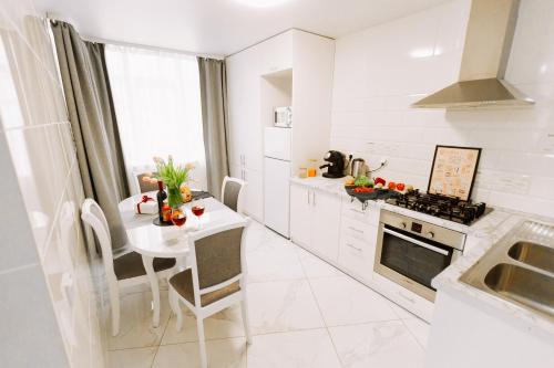 cocina blanca con mesa y fogones en Black&White Нова стильна квартира на Київській en Ternopilʼ