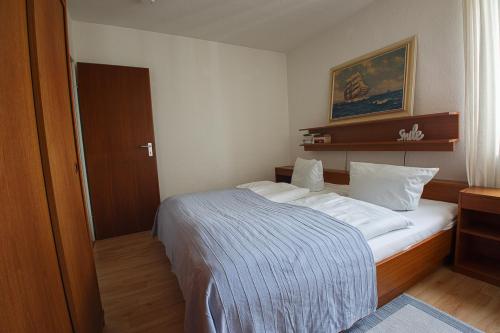 Un dormitorio con una cama con una manta azul. en Haus Uthlande Uthlande Whg 45 Ostwind en Wyk auf Föhr