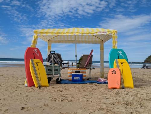 a gazebo and surfboards on the beach at Unit 2 Coolum Terraces in Coolum Beach