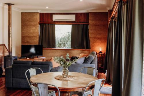 a living room with a table and a couch at Balingup Jalbrook Cottages Jalbrook Estate in Balingup
