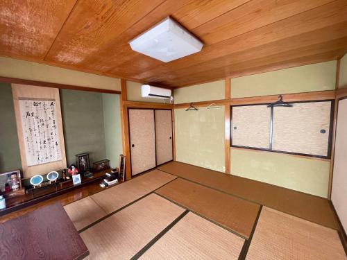 una stanza vuota con due finestre e un soffitto in legno di 大聖坊 Daishobo a Tsuruoka