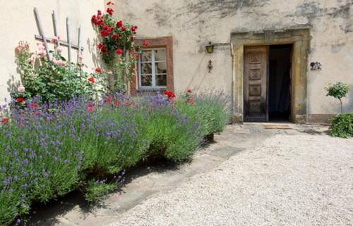 a building with flowers in front of a door at Ferienhof "Die Schenkenau" in Bodelstadt