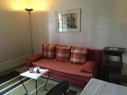 a living room with a red couch and a table at Ferienhof "Die Schenkenau" in Bodelstadt