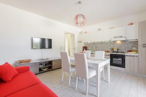 eine Küche und ein Esszimmer mit einem weißen Tisch und Stühlen in der Unterkunft DELFINO - Ampio Appartamento a 40 metri dalla Spiaggia in Lido Conchiglia