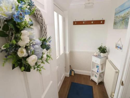 a hallway with a wreath of flowers on the wall at Clover Cottage in Haverfordwest