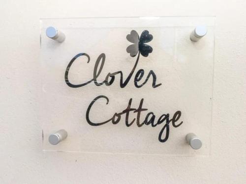 una señal para una oficina de vidrio con una flor en ella en Clover Cottage en Haverfordwest