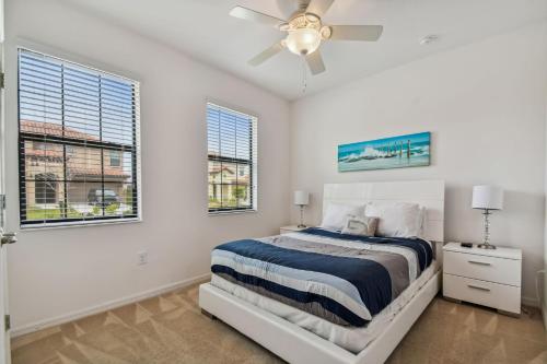 a white bedroom with a bed and two windows at Large family friendly Vacation Home, Private Pool, Golf course location, Nr Orlando Disney Parks Florida in Davenport
