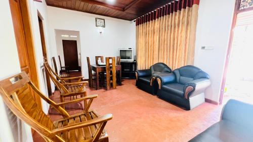 un soggiorno con sedie, divano e tavolo di Allan Villa a Midigama East