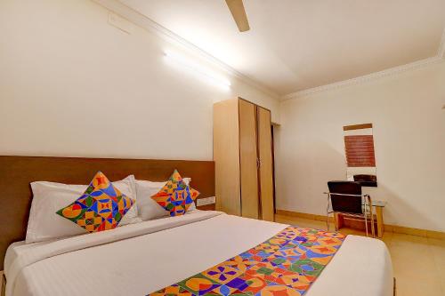 a bedroom with a large bed with colorful pillows at FabHotel Royal Park Residency in Chennai