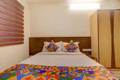 a bedroom with a bed with a colorful comforter at FabHotel Royal Park Residency in Chennai