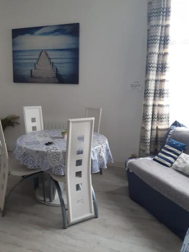 een kamer met een tafel, een tafel en een stoel bij meublé saisonnier plage in Duinkerke