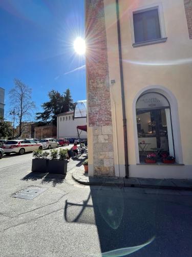 un edificio con riflesso nell'acqua vicino a una strada di Hotel Caffè Verdi - 24 hours Reception a Pisa