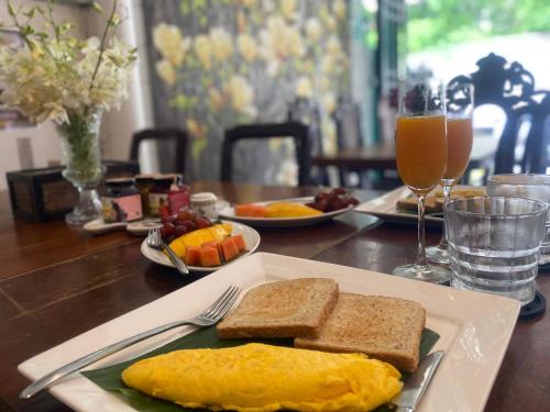 a table with a plate of breakfast foods and drinks at Cafe ice resident in Yan Nawa