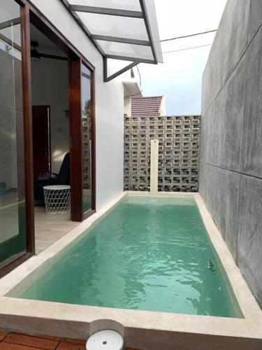 a swimming pool in the middle of a house at Davyn's House - Cozy and Private House in Lombok in Prampuan