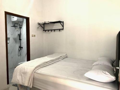 um quarto branco com uma cama e um espelho em Davyn's House - Cozy and Private House in Lombok em Prampuan
