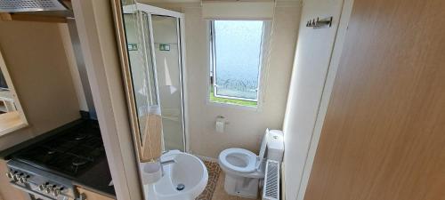 een kleine badkamer met een toilet en een wastafel bij Heerlijk aan het strand in Hoek van Holland