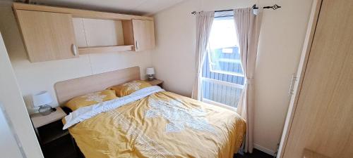 Habitación pequeña con cama y ventana en Heerlijk aan het strand, en Hoek van Holland