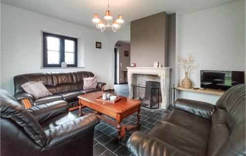a living room with leather furniture and a fireplace at Lovely Home In Knesselare With Wifi in Knesselare