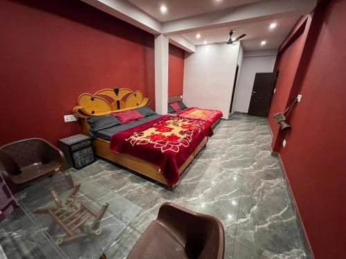 a bedroom with a bed and chairs in it at Shanti Cafe & Hostels in Kasol