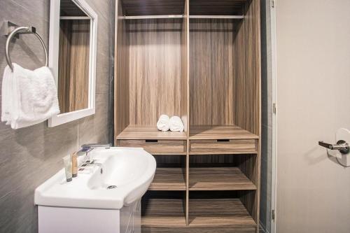 ein Badezimmer mit einem Waschbecken, einem WC und einem Spiegel in der Unterkunft Anika Suites in Cebu City